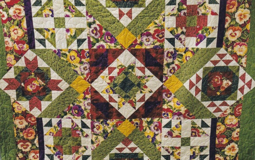 vibrant pansies form a giant star in this lovely quilt